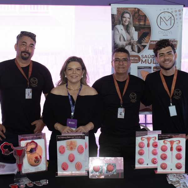 Equipe expositora apresentando materiais educativos sobre saúde da mulher no Gineca Weekend.